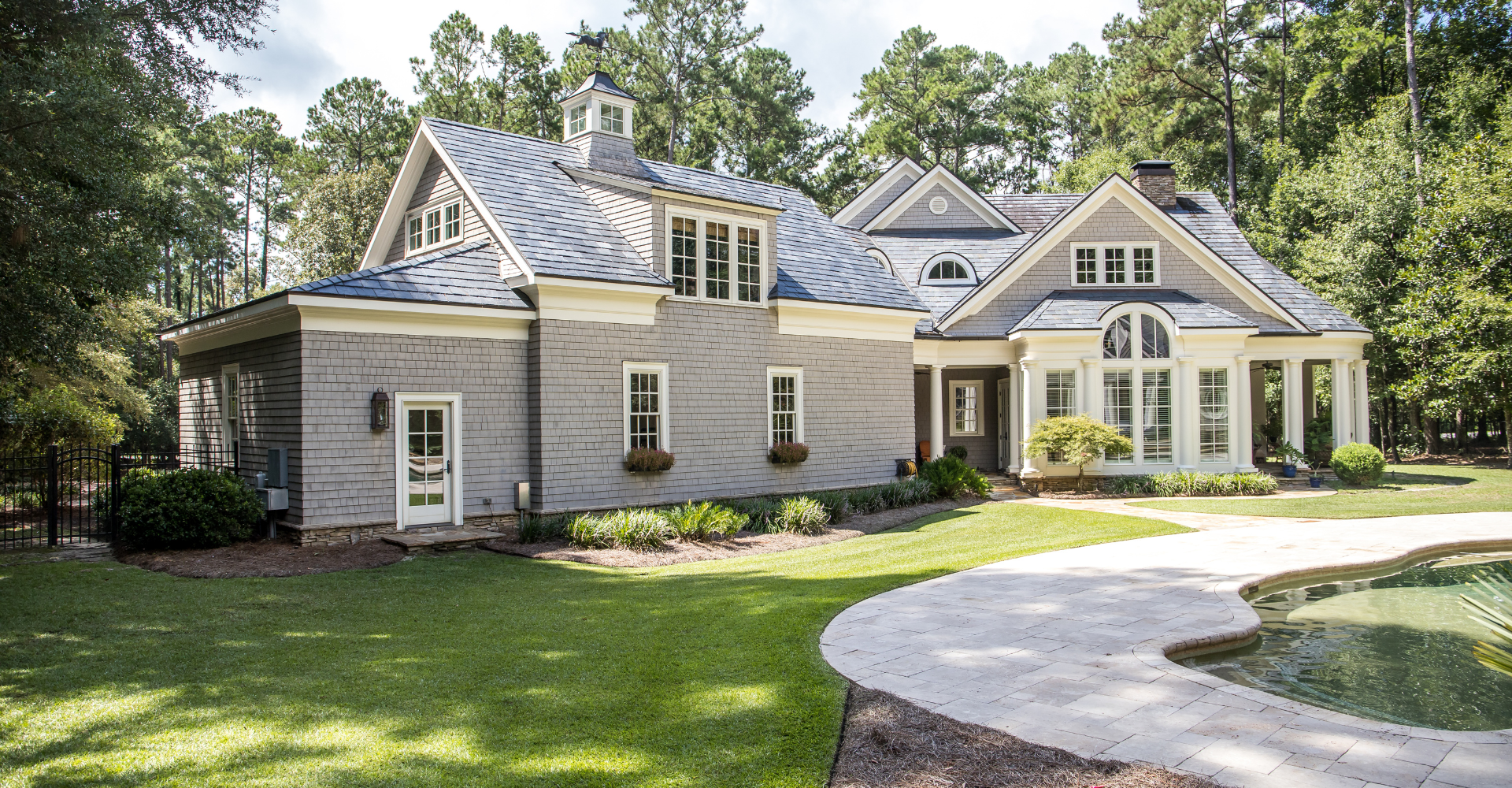 A large house with a swimming pool in front of it