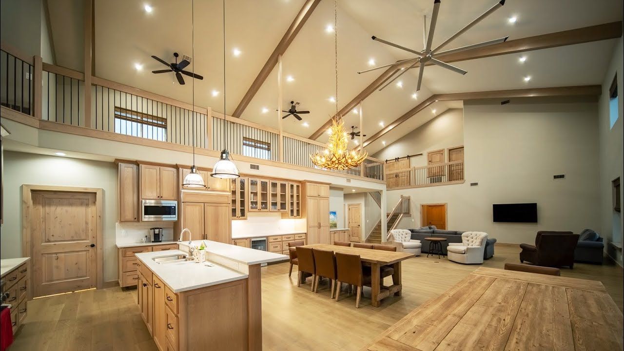 A large house with a kitchen , dining room , living room and ceiling fan.