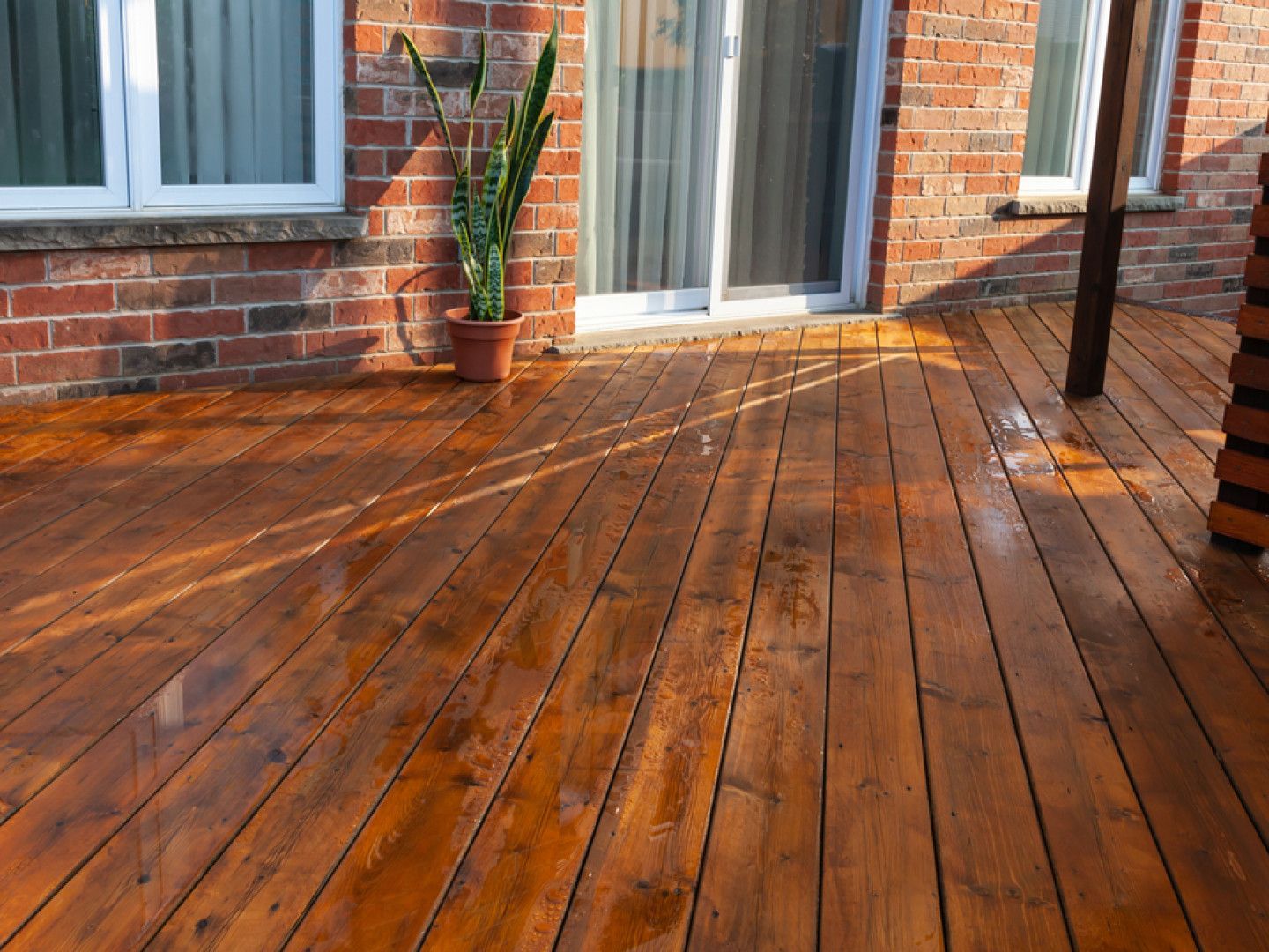 Beautiful stained deck with dark wood by Compass Construction