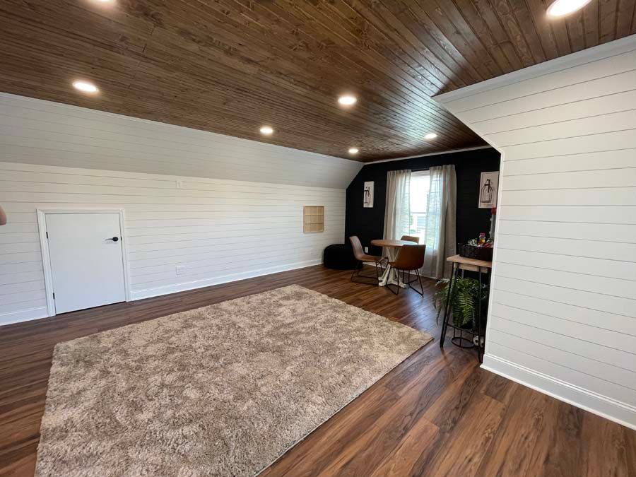 A living room with hardwood floors and a wooden ceiling.