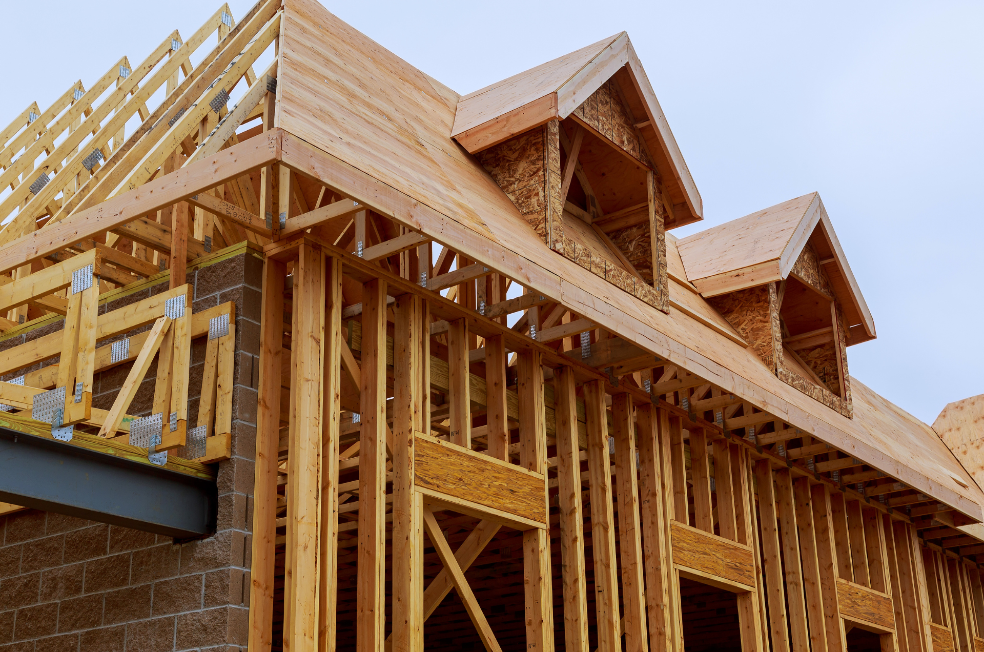 A house is being built with wooden beams and a roof.