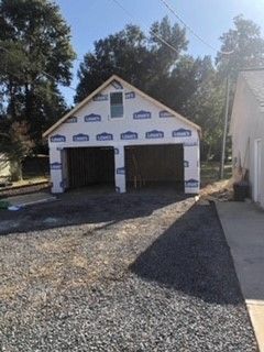 A garage is being built in the backyard of a house.