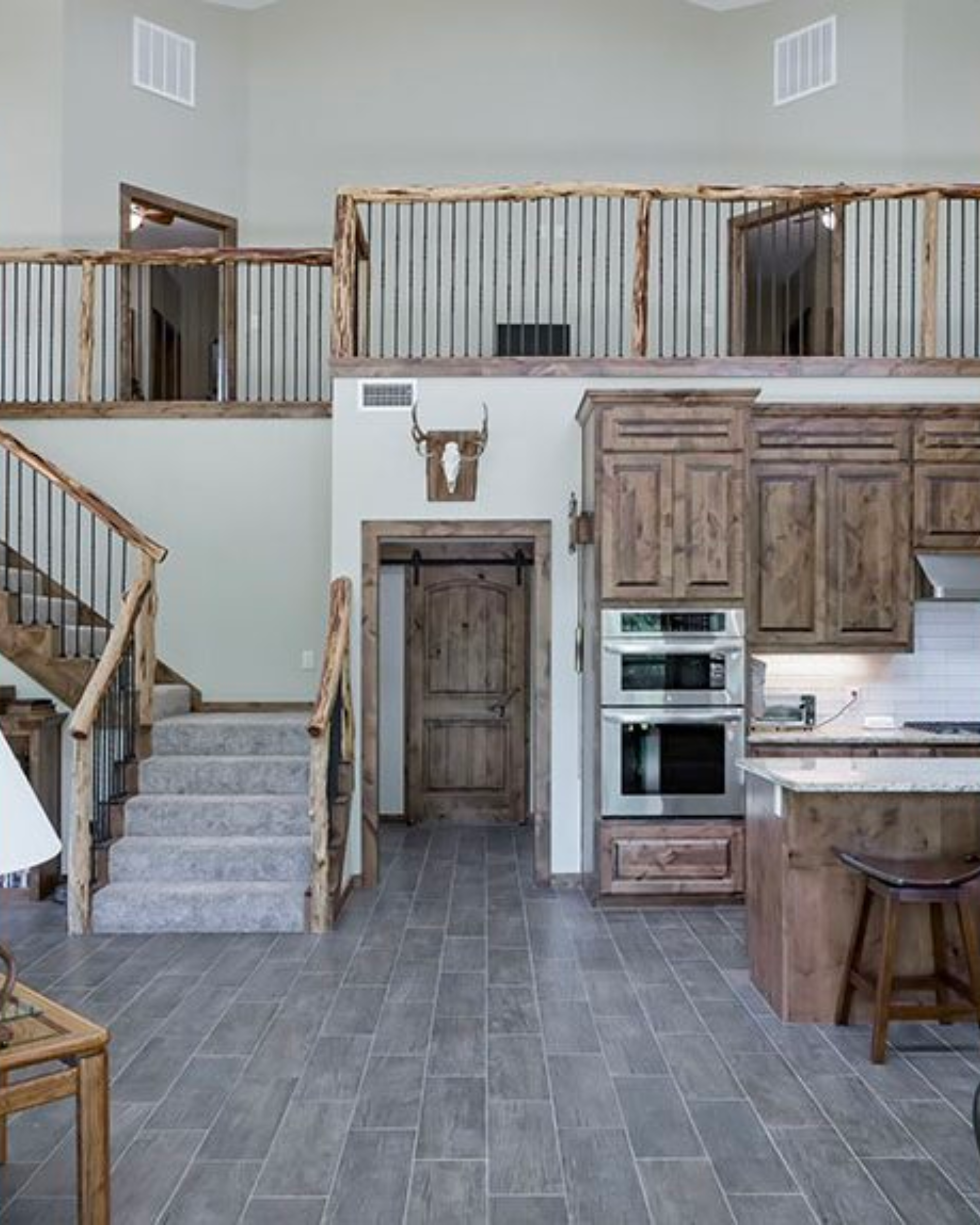 Gorgeous Interior of a two-level barndominium with wood grain acdents throughout the rustic vintage interior design