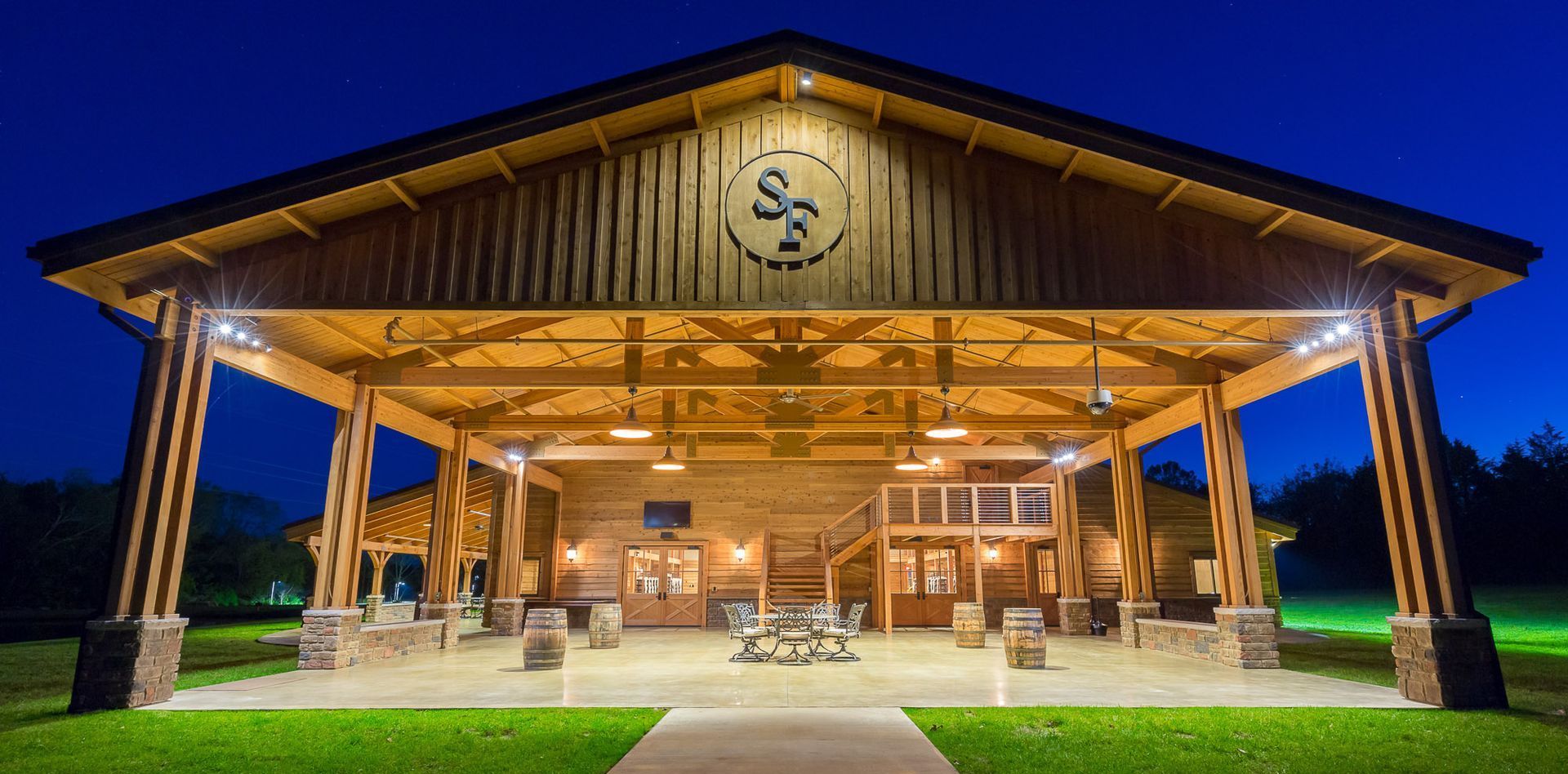 A large wooden pavilion is lit up at night.