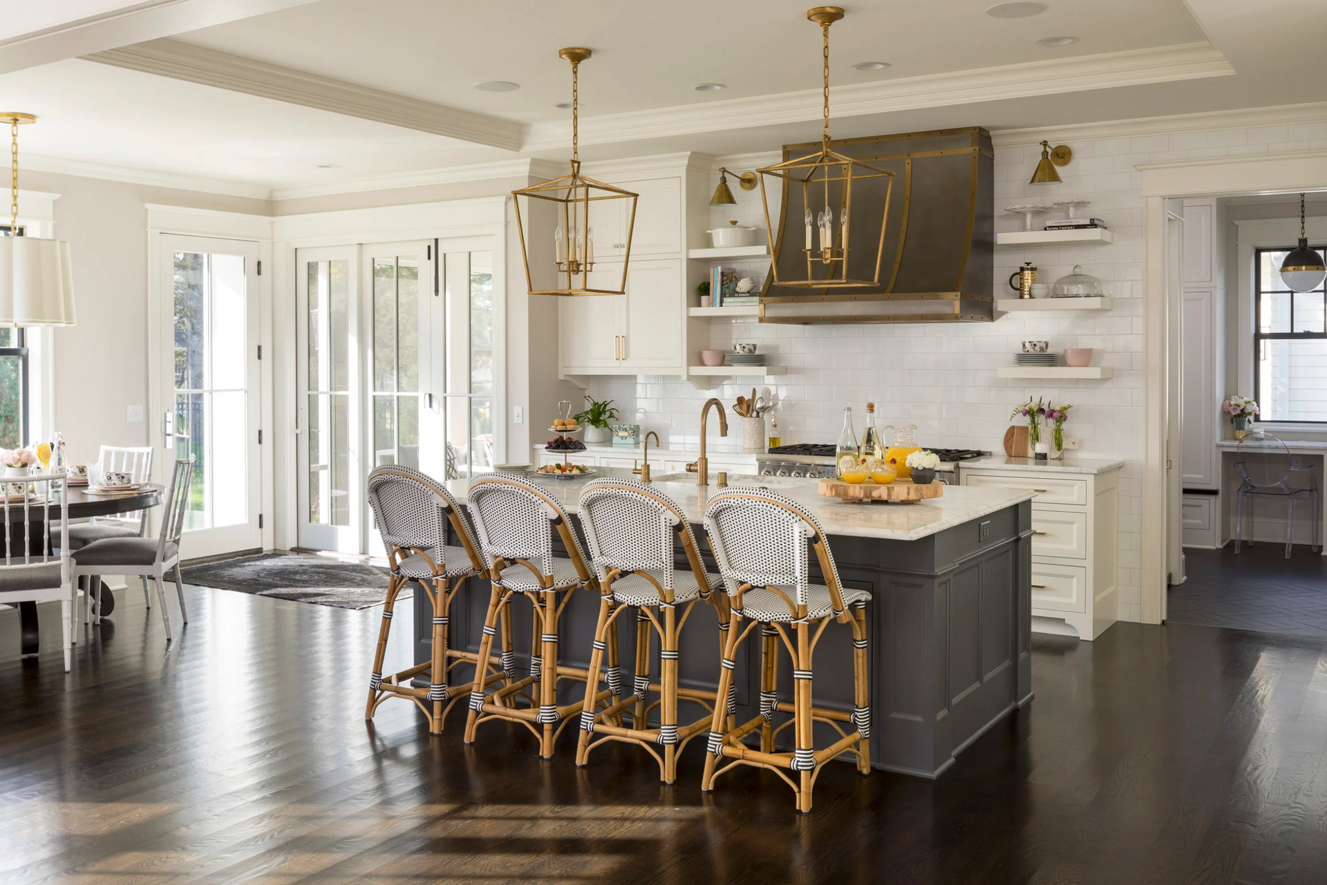 A kitchen with a large island and stools in it.