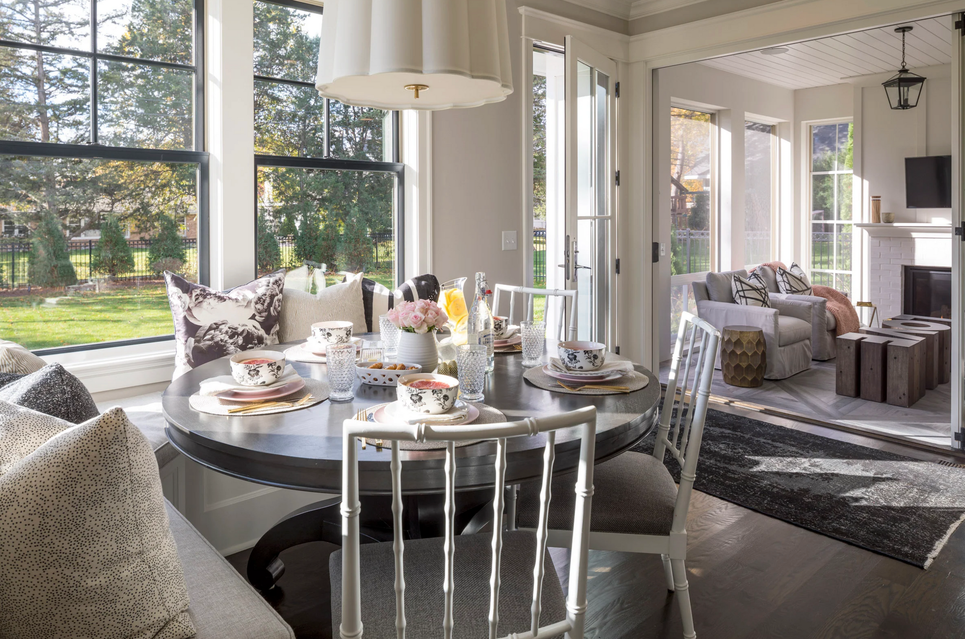 A dining room with a round table and white chairs