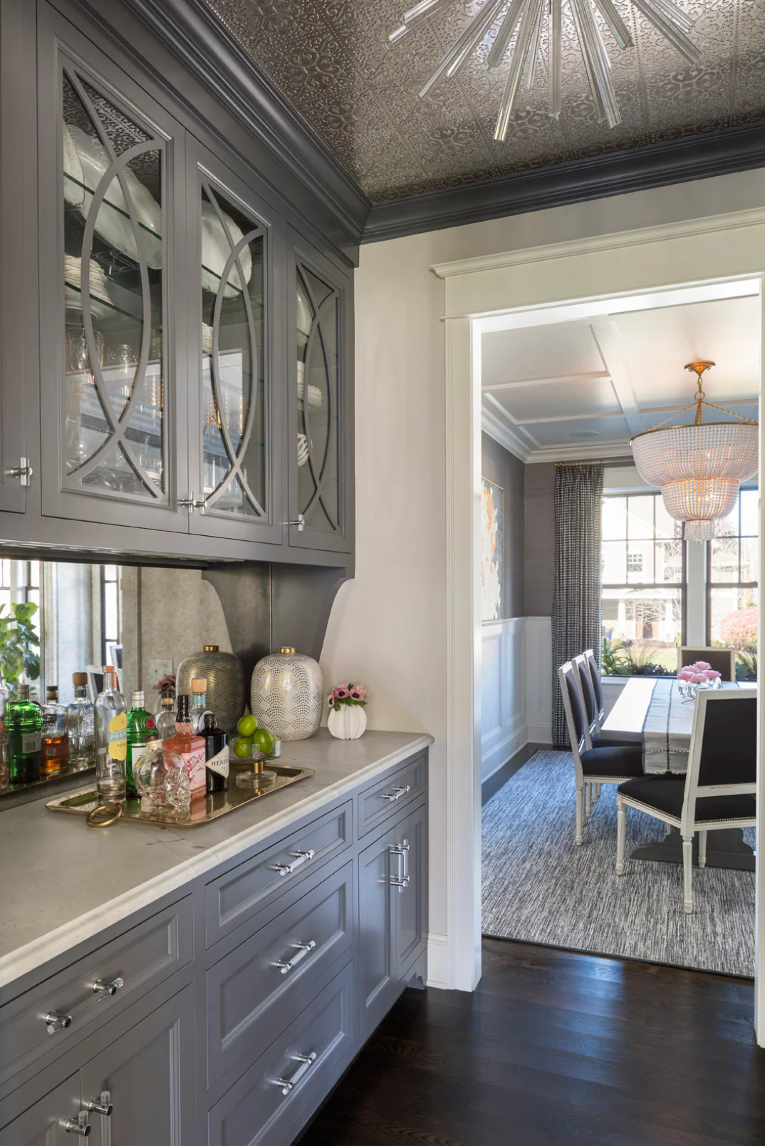 A kitchen with a bar and a dining room in the background.