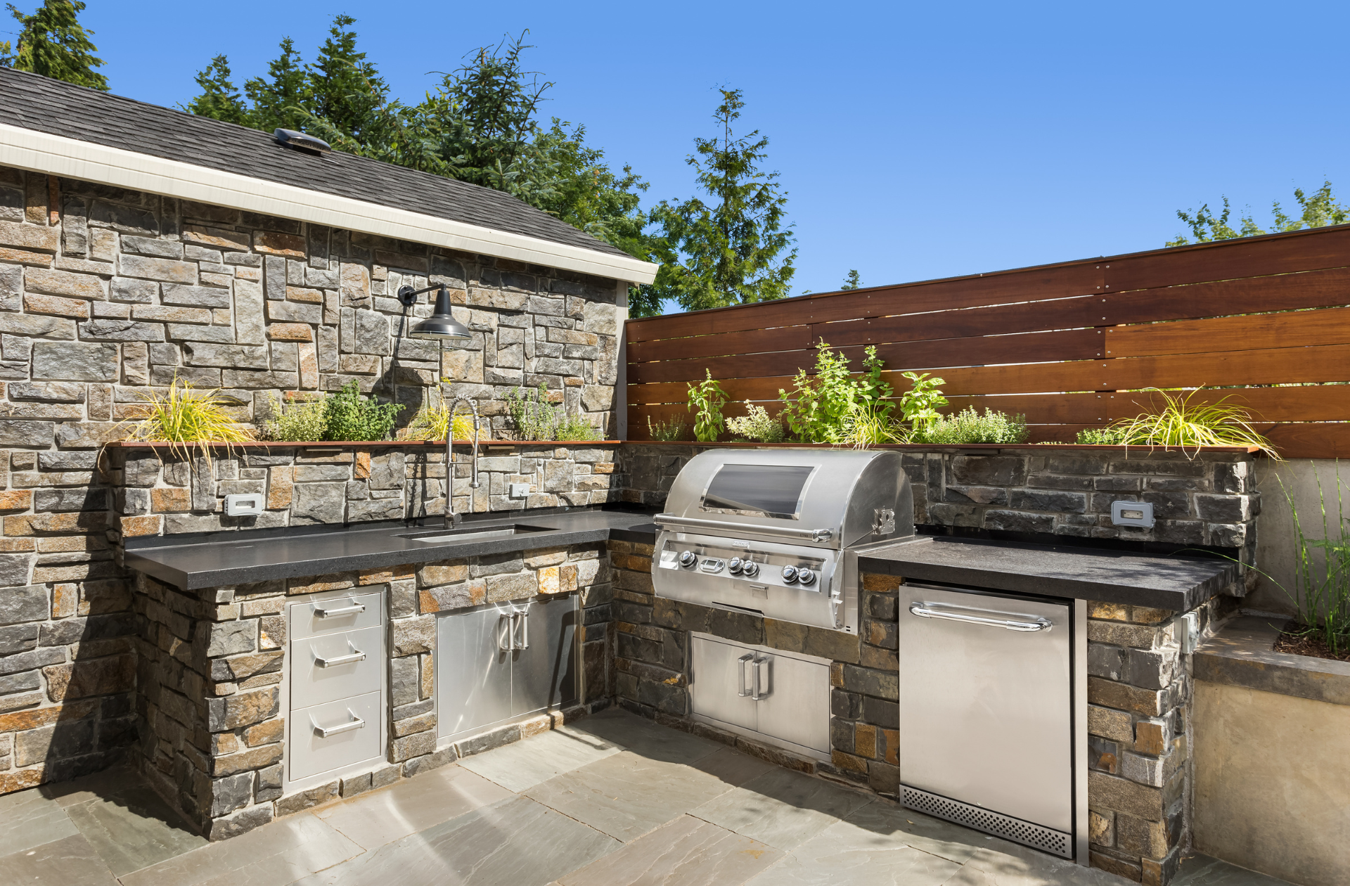 outdoor kitchen with stonework and wooden finishing touches with permanent grill installation