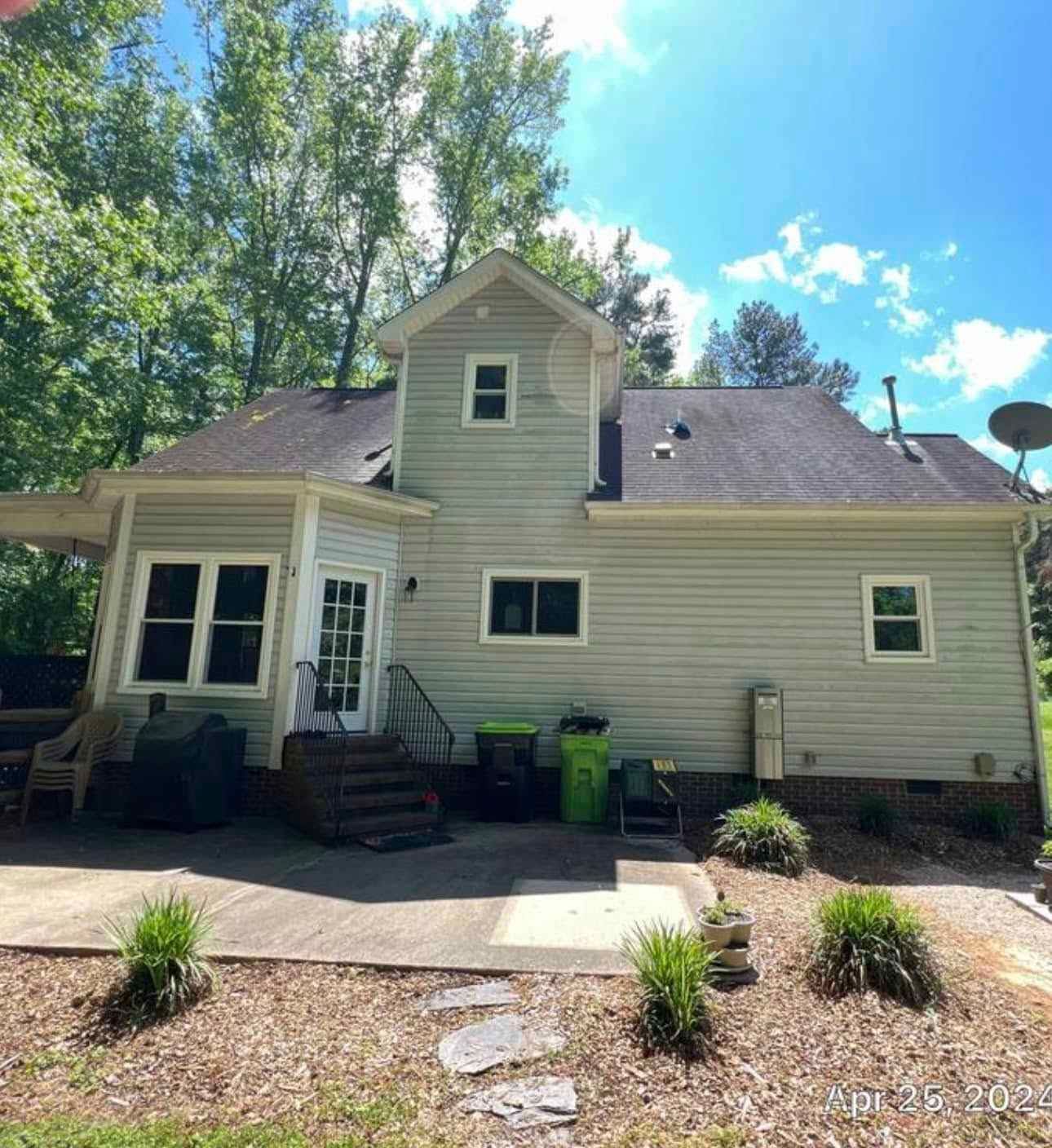 A white house with a black roof is for sale.