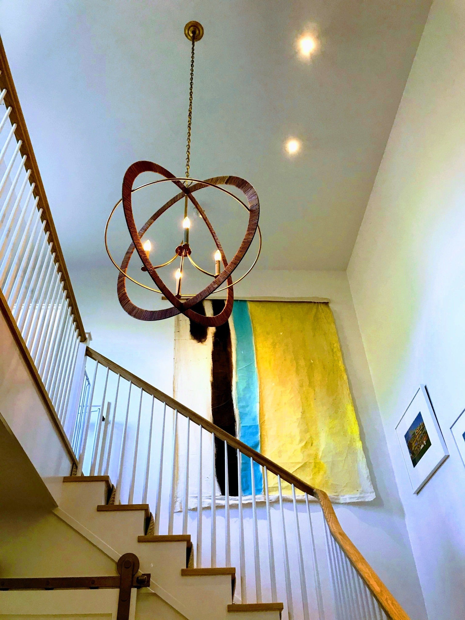 A staircase with a chandelier hanging from the ceiling