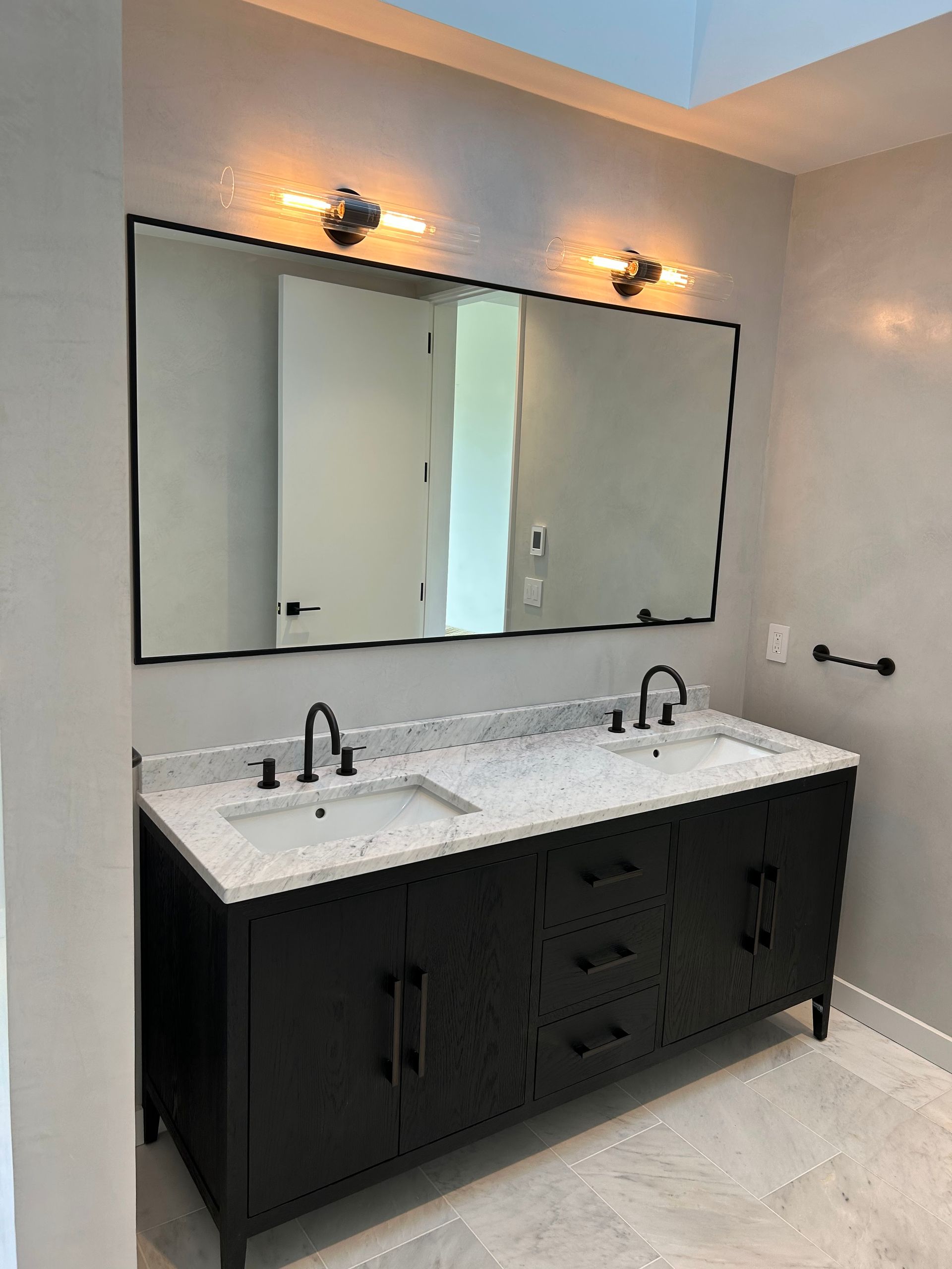 A bathroom with two sinks and a large mirror.