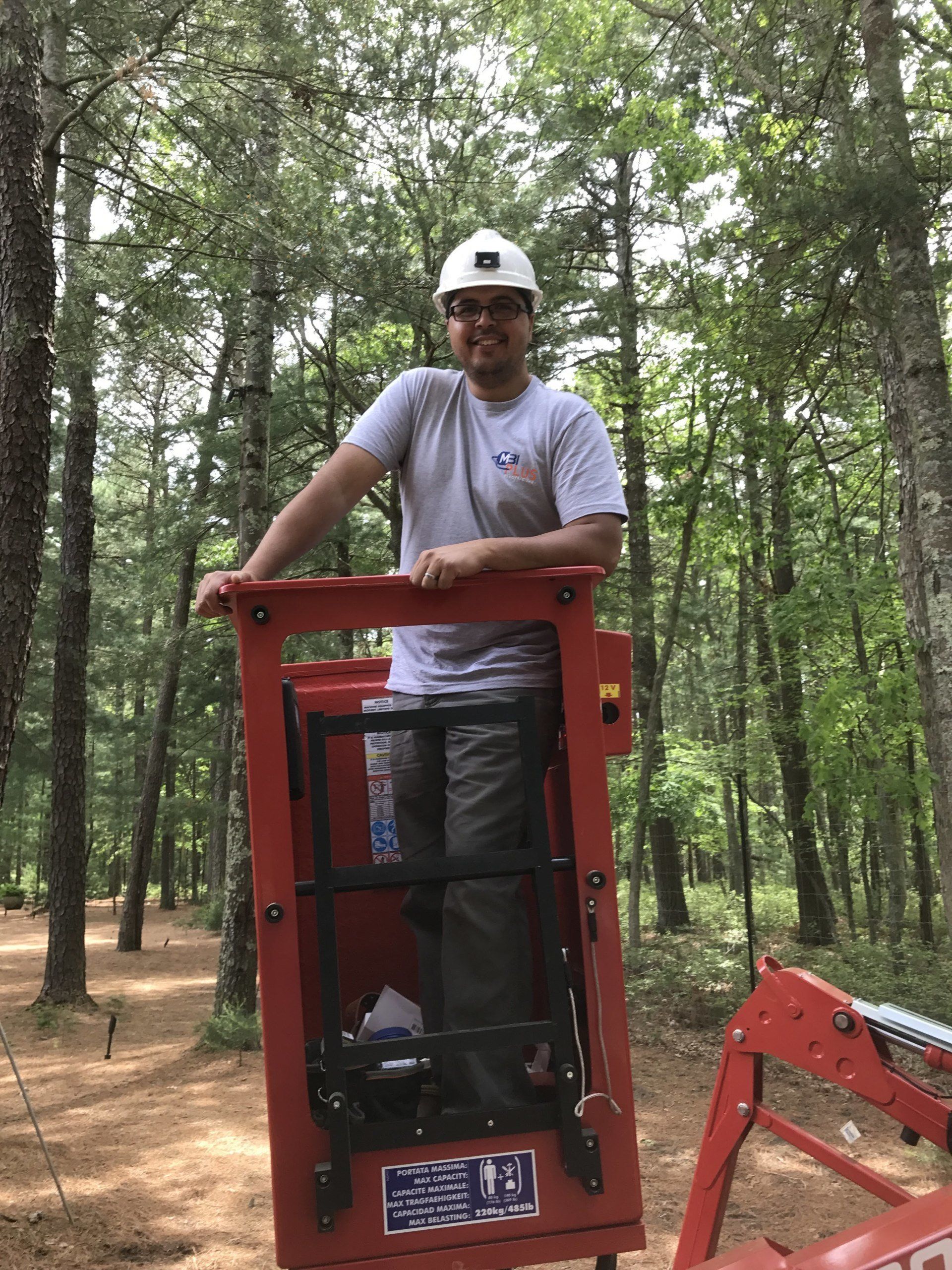 A man is standing in a lift in the woods.