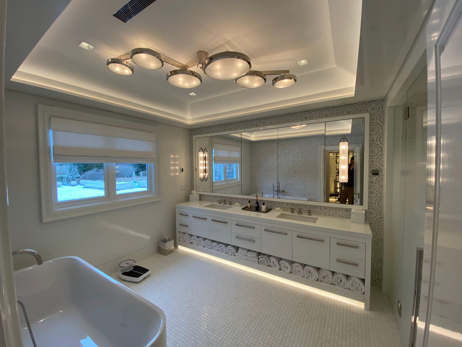 A bathroom with two sinks , a bathtub , and a large mirror.