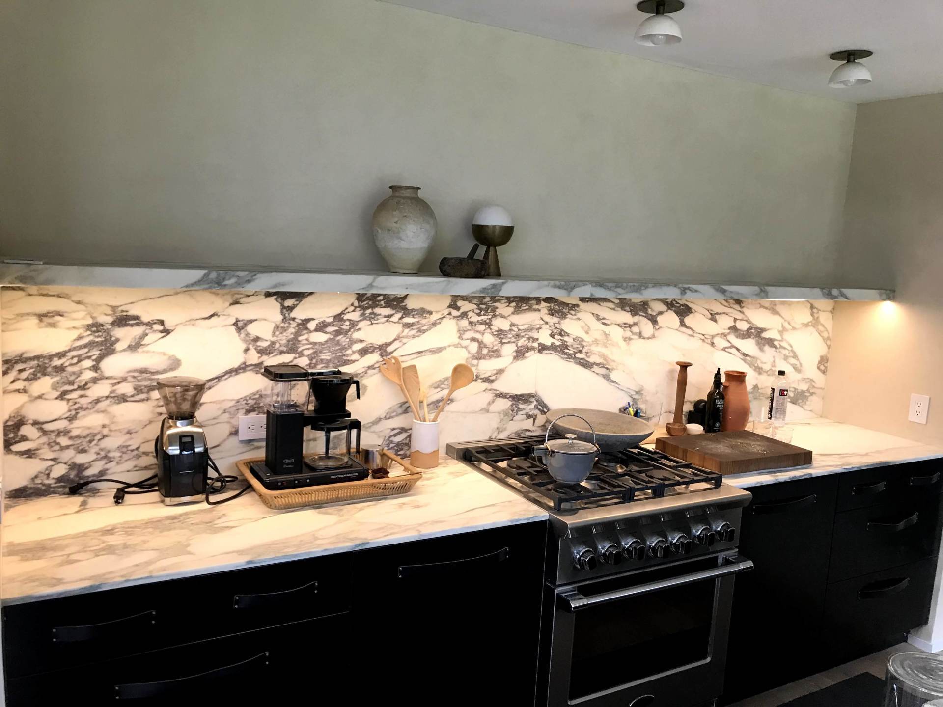A kitchen with a stove and a coffee maker on the counter.