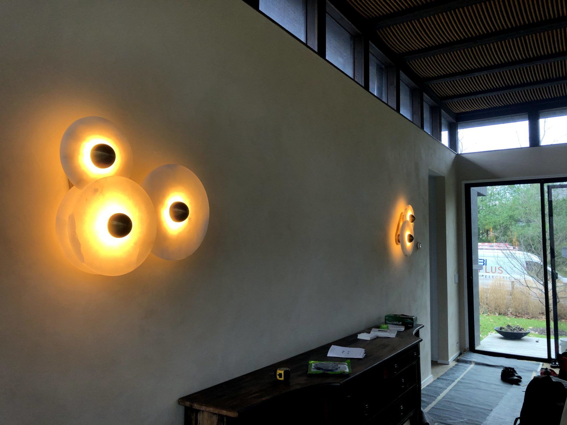 A room with two lights on the wall and a sliding glass door.