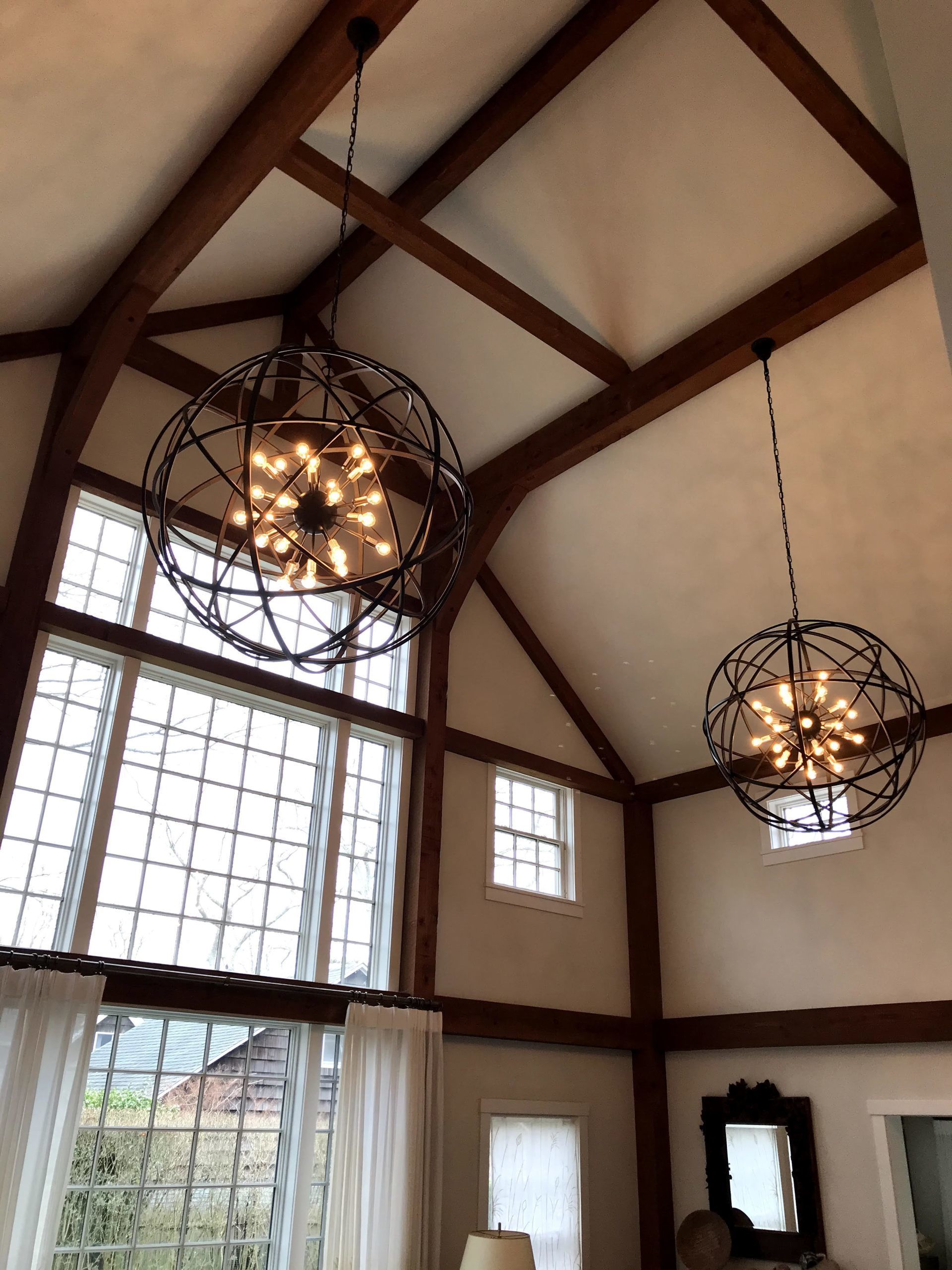 A living room with two chandeliers hanging from the ceiling