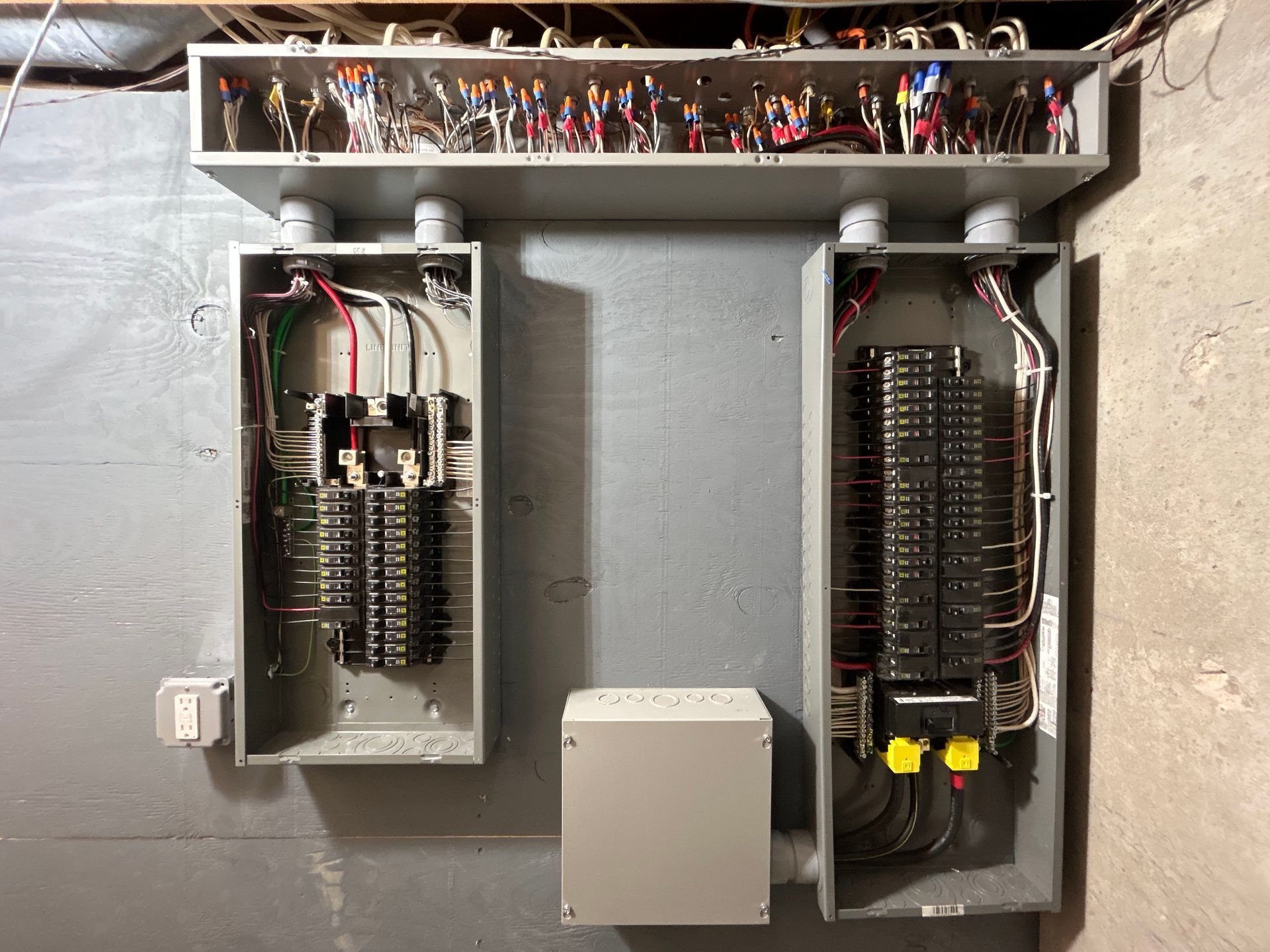 Two electrical boxes are hanging on a wall.