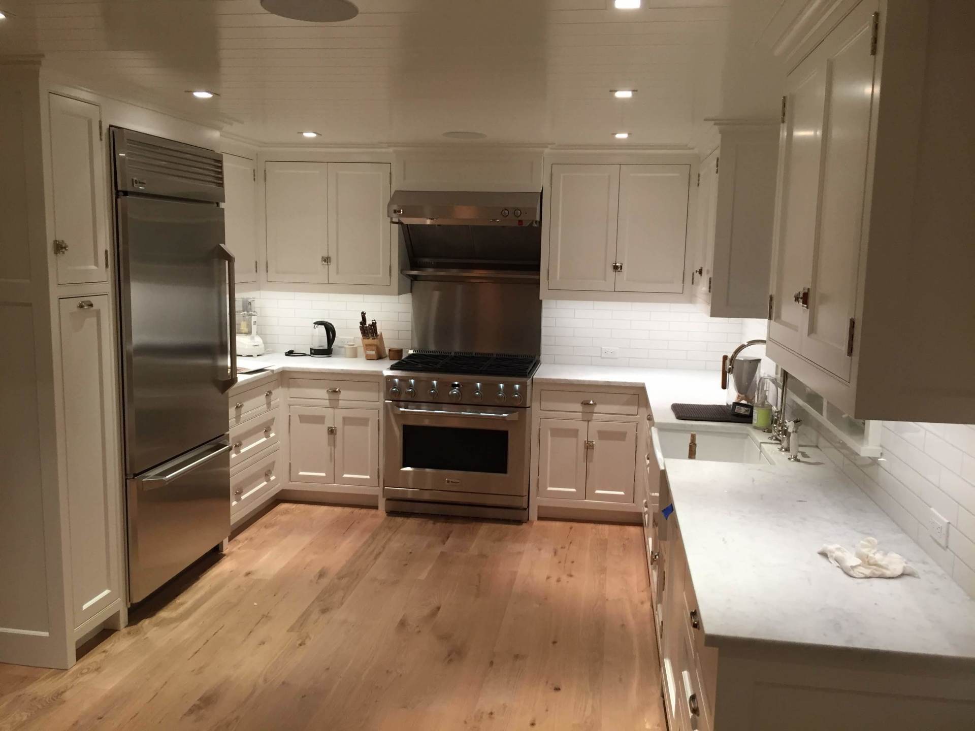 A kitchen with white cabinets and stainless steel appliances