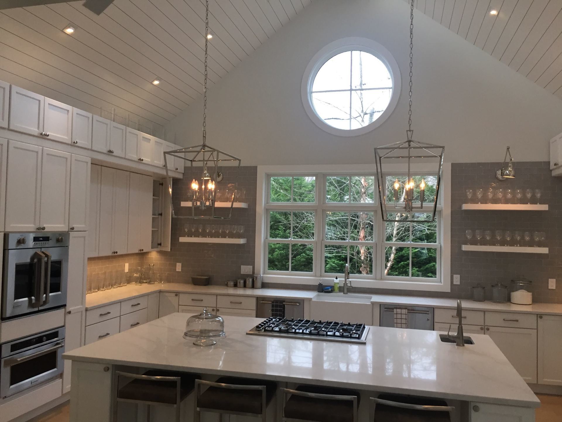 A kitchen with white cabinets and a large island