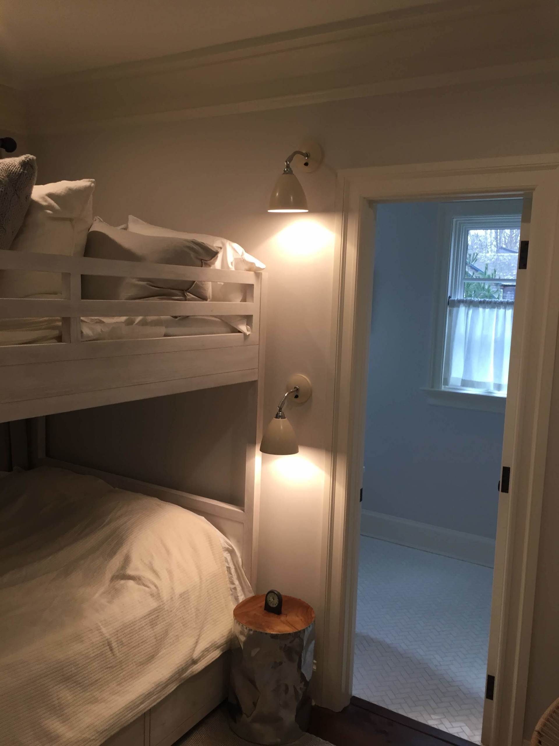 A bedroom with bunk beds and a door leading to a bathroom.