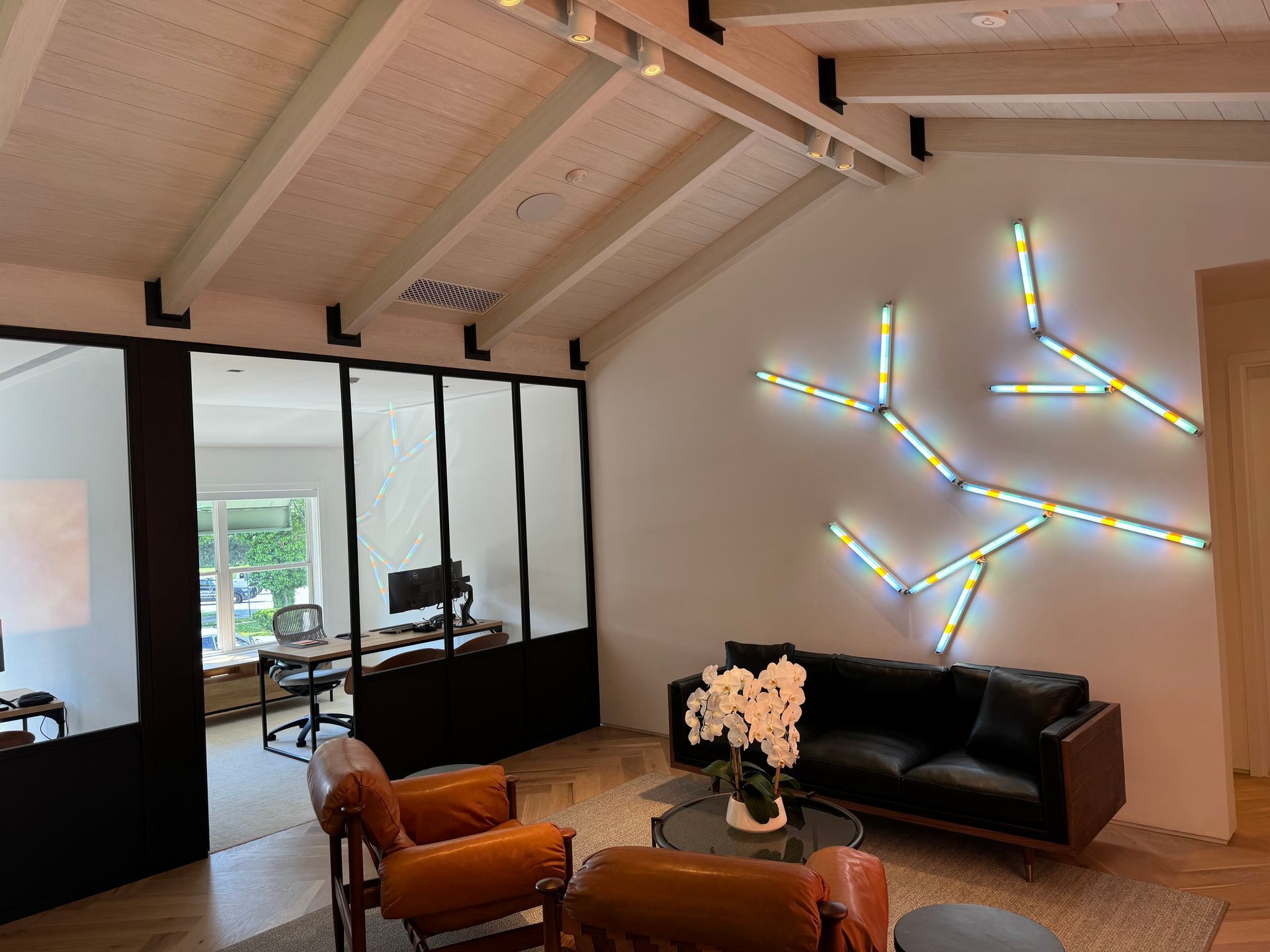 A living room with a couch , chairs and a painting on the wall.
