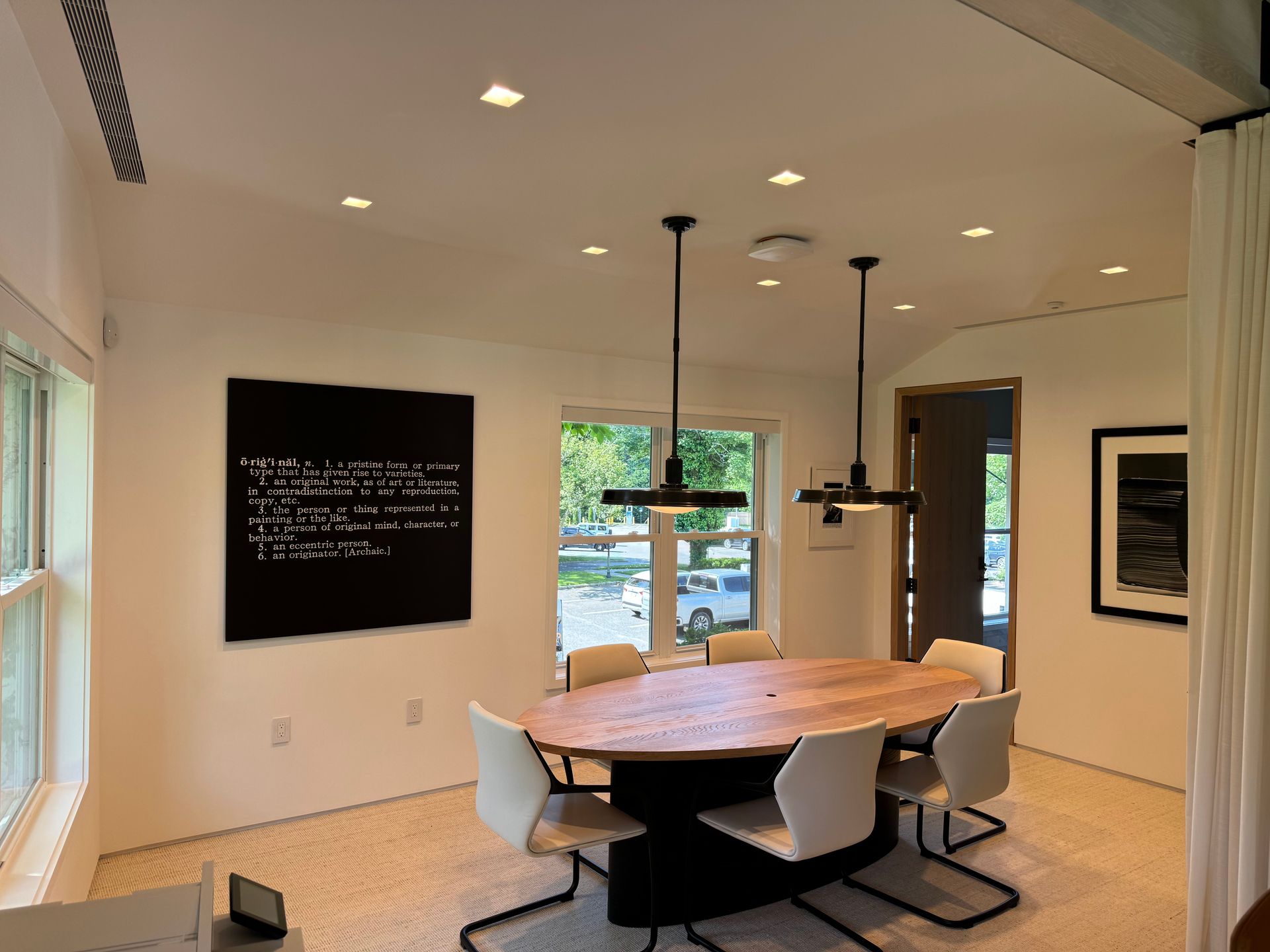 A dining room with a round table and white chairs