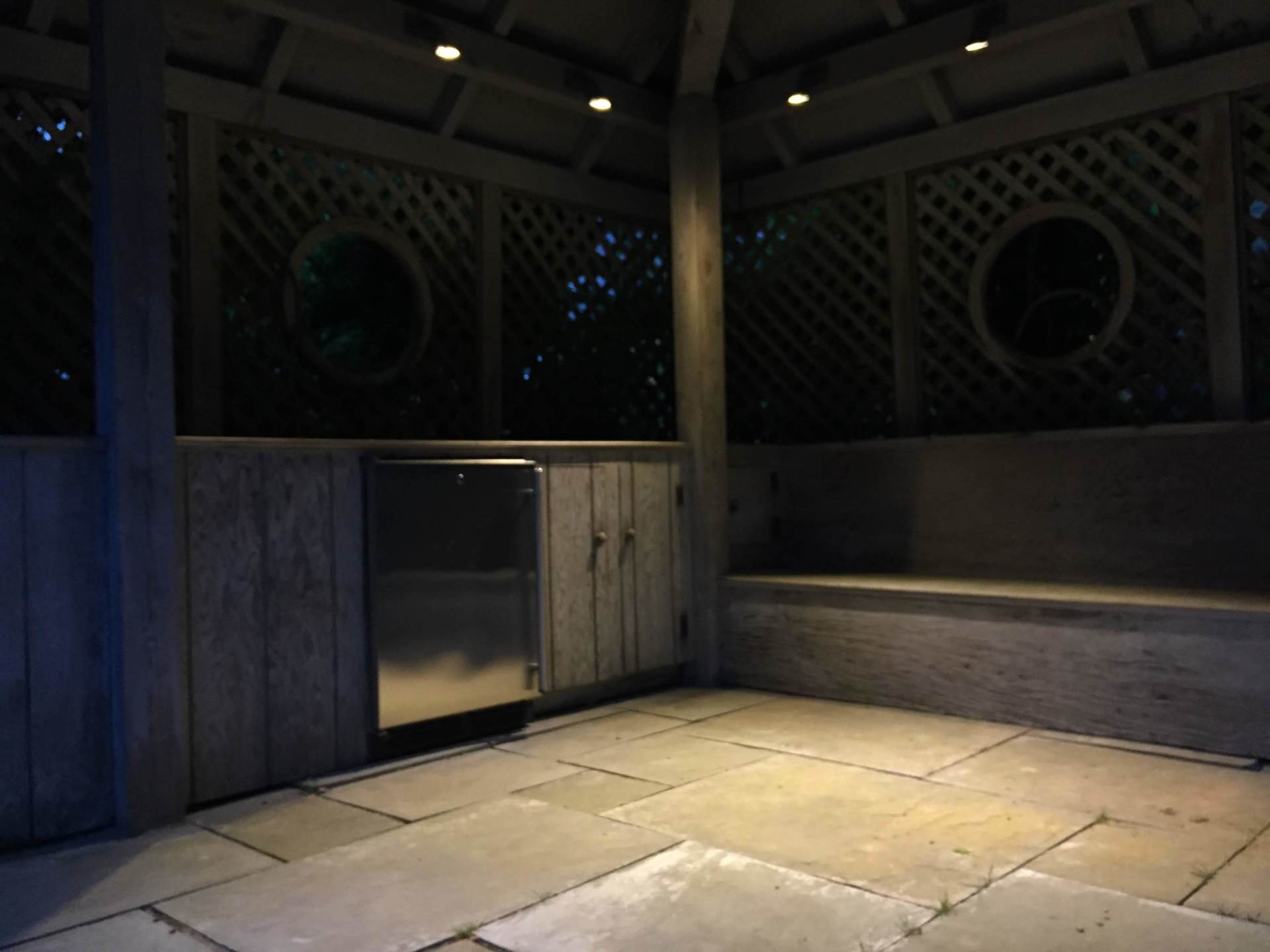 An empty gazebo at night with a stainless steel dishwasher