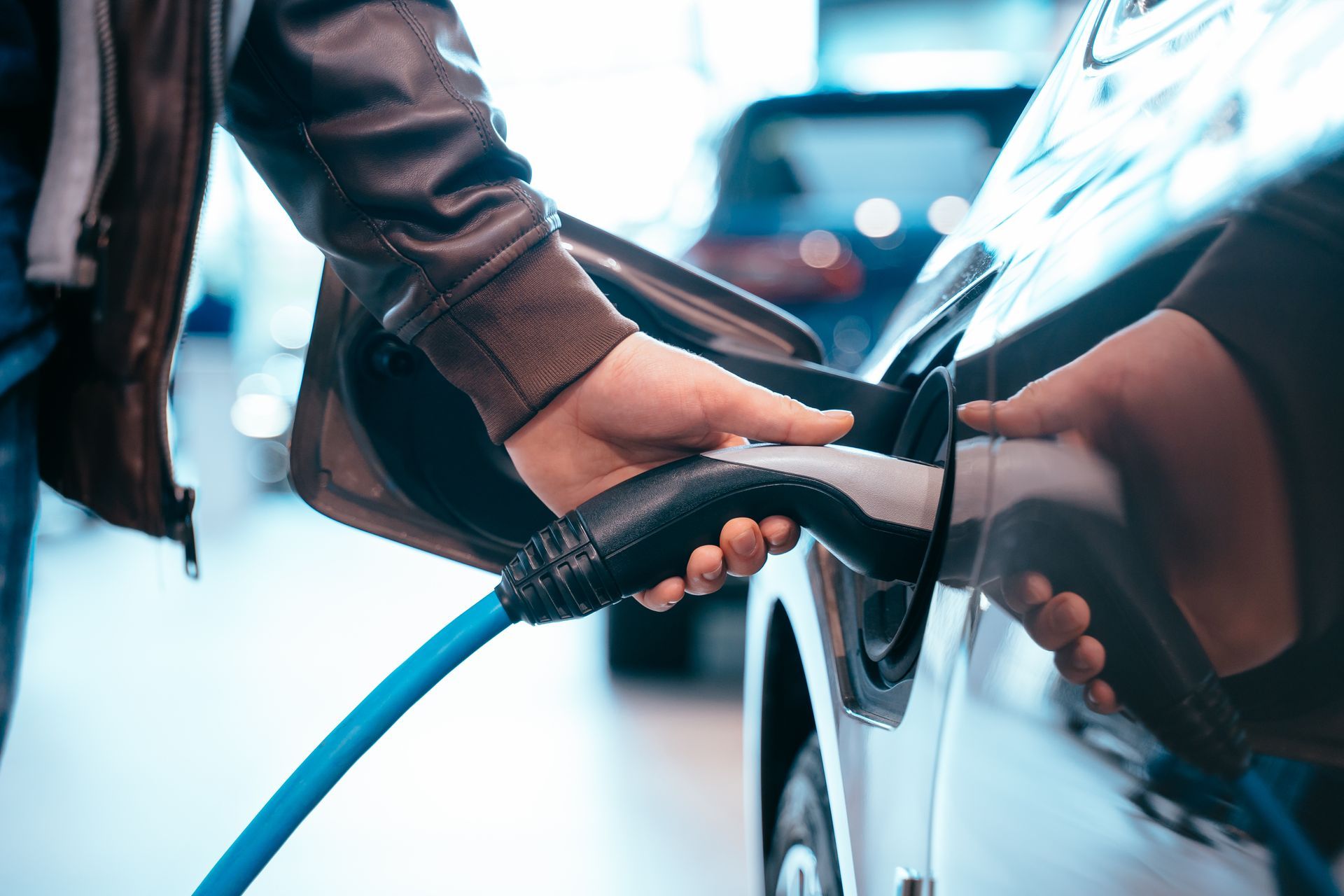 un homme recharge sa voiture sur une borne électrique