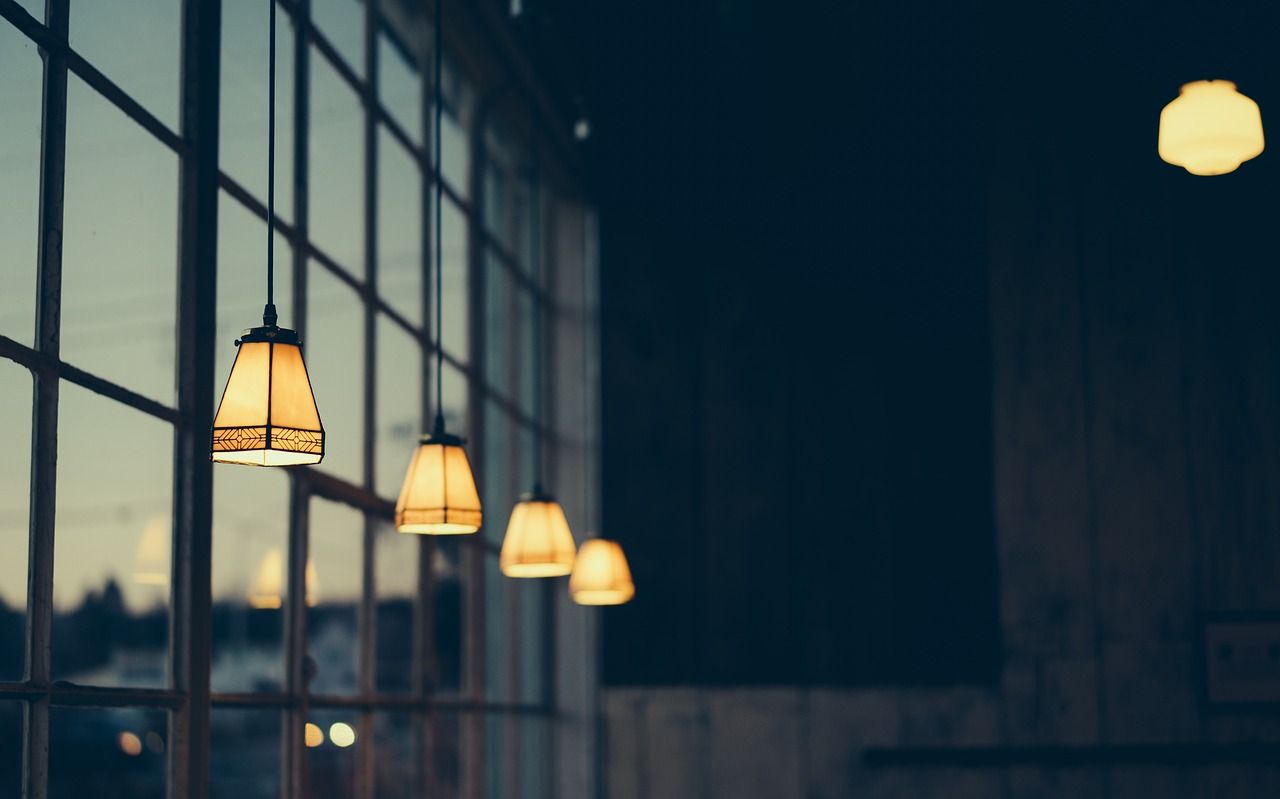 une rangée de lampes suspendues au plafond devant une fenêtre.