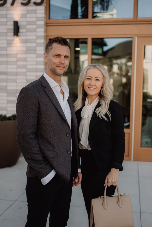 A man and a woman are standing next to each other in front of a building.