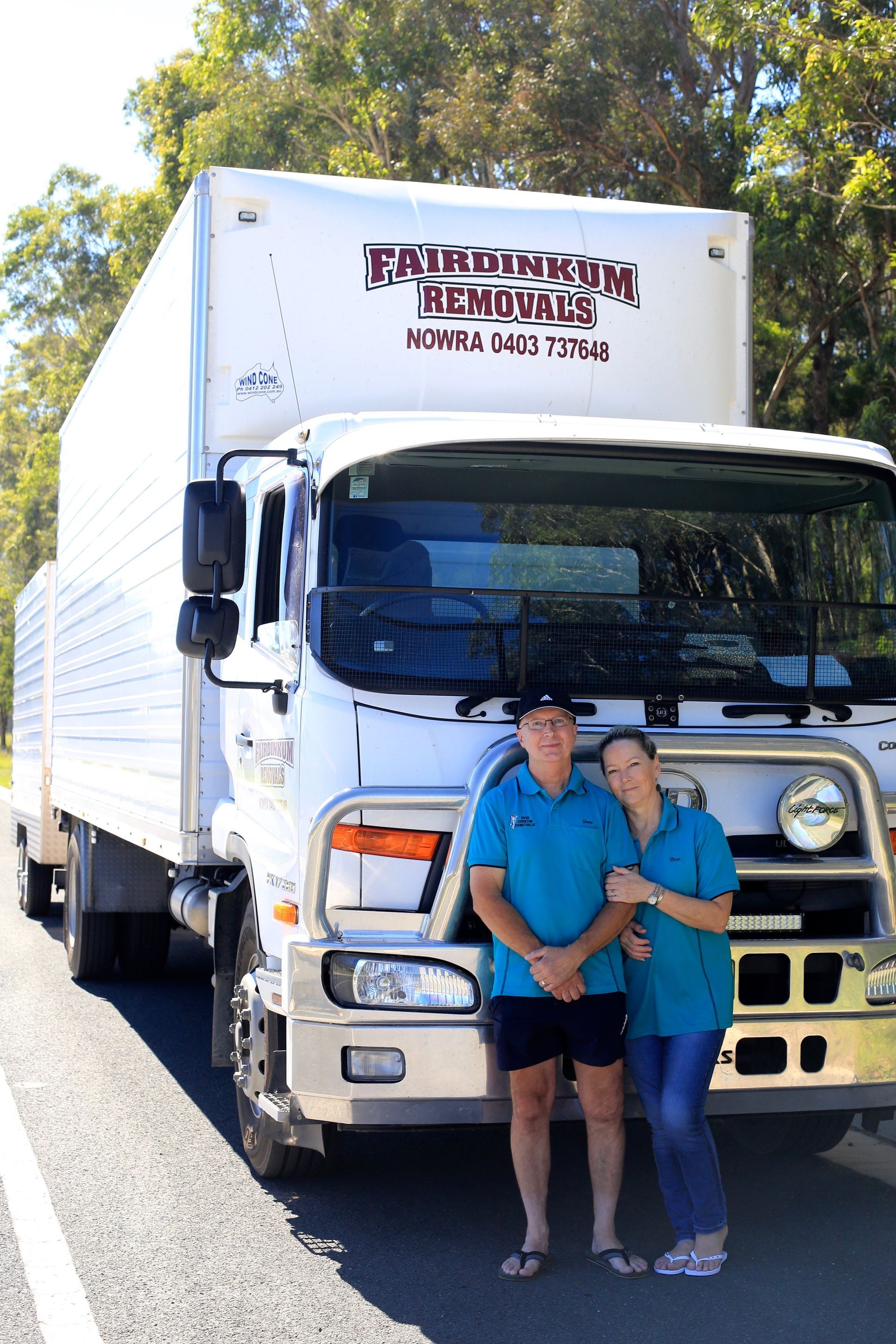 Two People Standing In Front Of Removalist Truck — Fairdinkum Removals In Berry, NSW