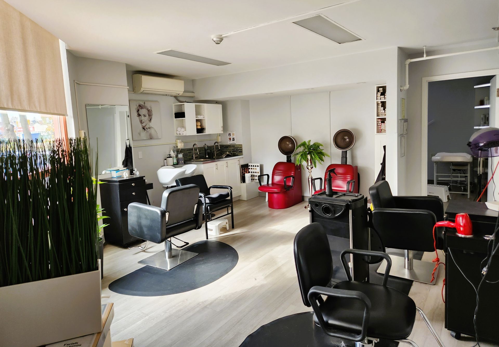 A hair salon with a lot of chairs and a sink.