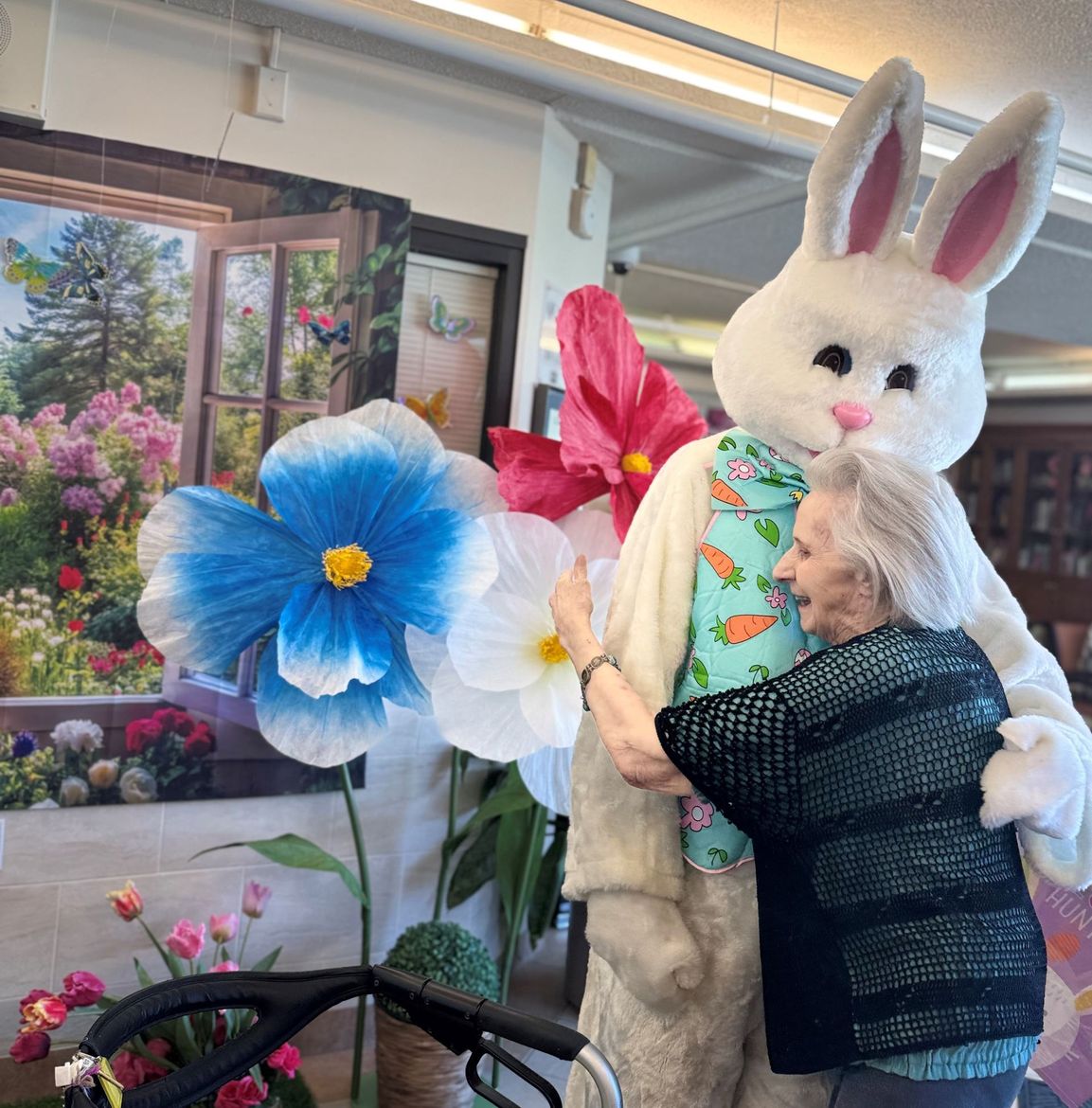 An elderly woman is hugging a stuffed bunny rabbit