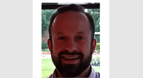 A man with a beard is smiling for the camera.