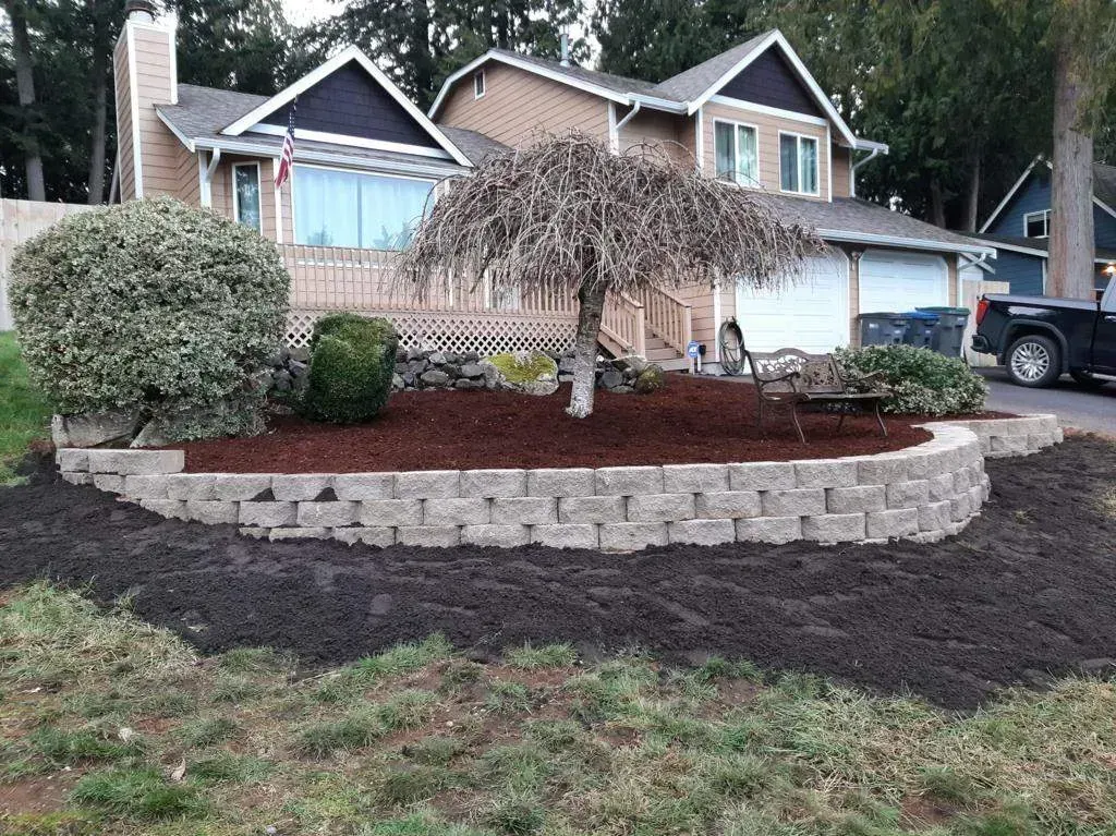 House with brick retaining wall and landscaped garden.