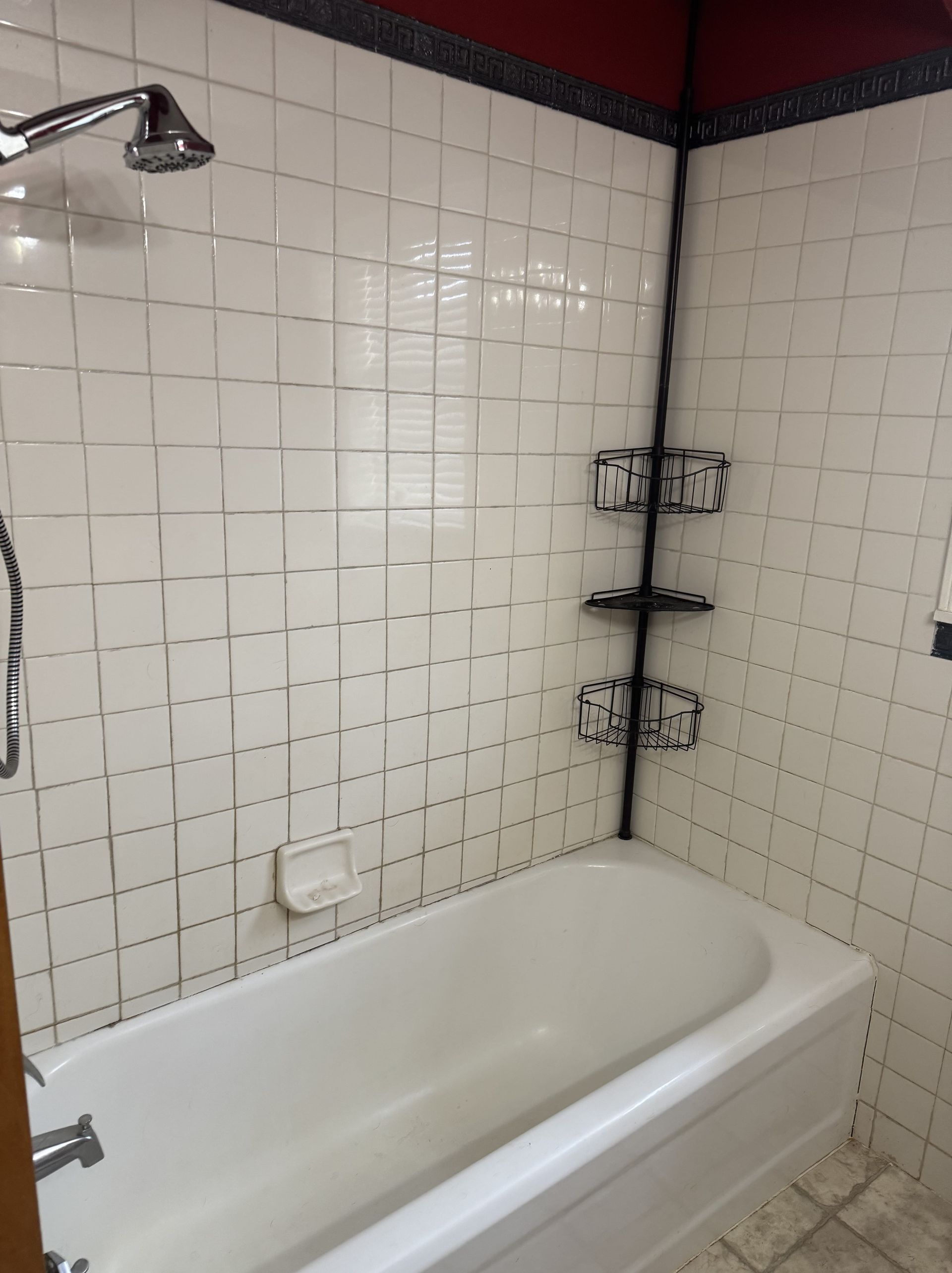 A bathroom with a toilet , tub , and washer and dryer.