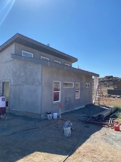 A man is standing in front of a house that is being built.