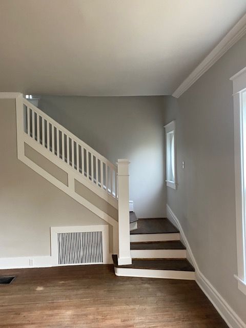 An empty living room with stairs leading up to the second floor