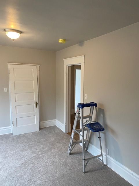 An empty room with a ladder in the corner