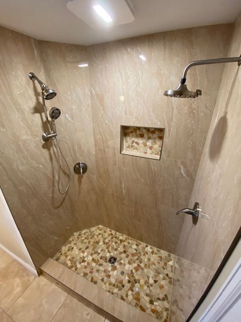 A bathroom with a walk in shower and two shower heads.