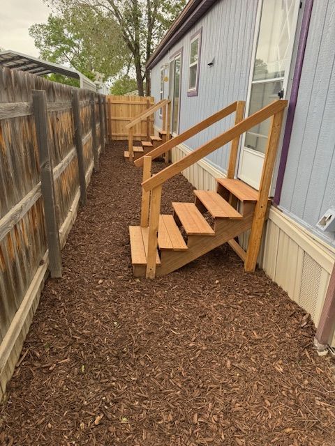 A blue house with wooden stairs leading up to it