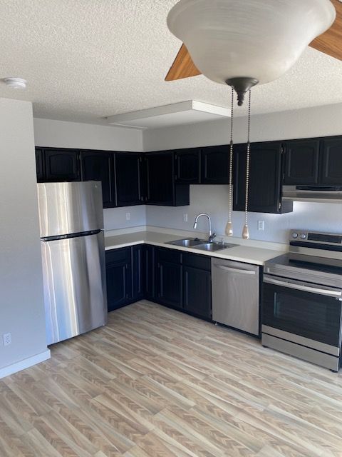 A kitchen with black cabinets and stainless steel appliances