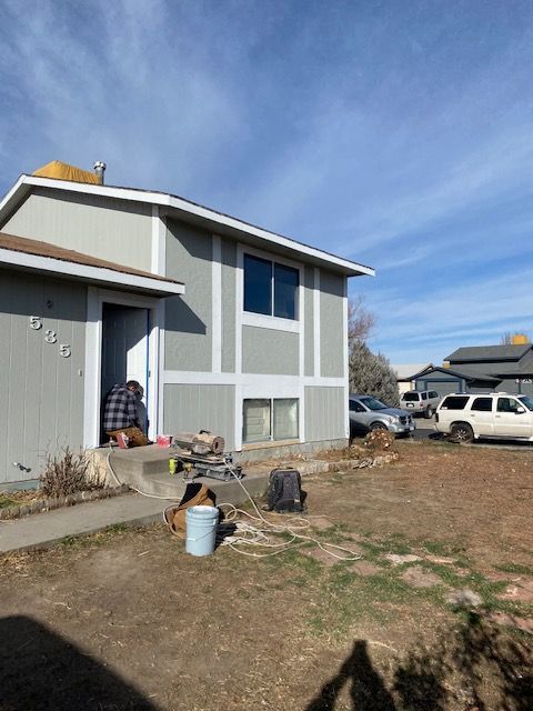 A man is sitting on the porch of a house.