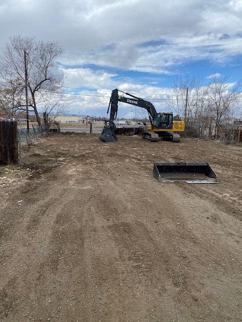 An excavator is moving dirt in a dirt field.