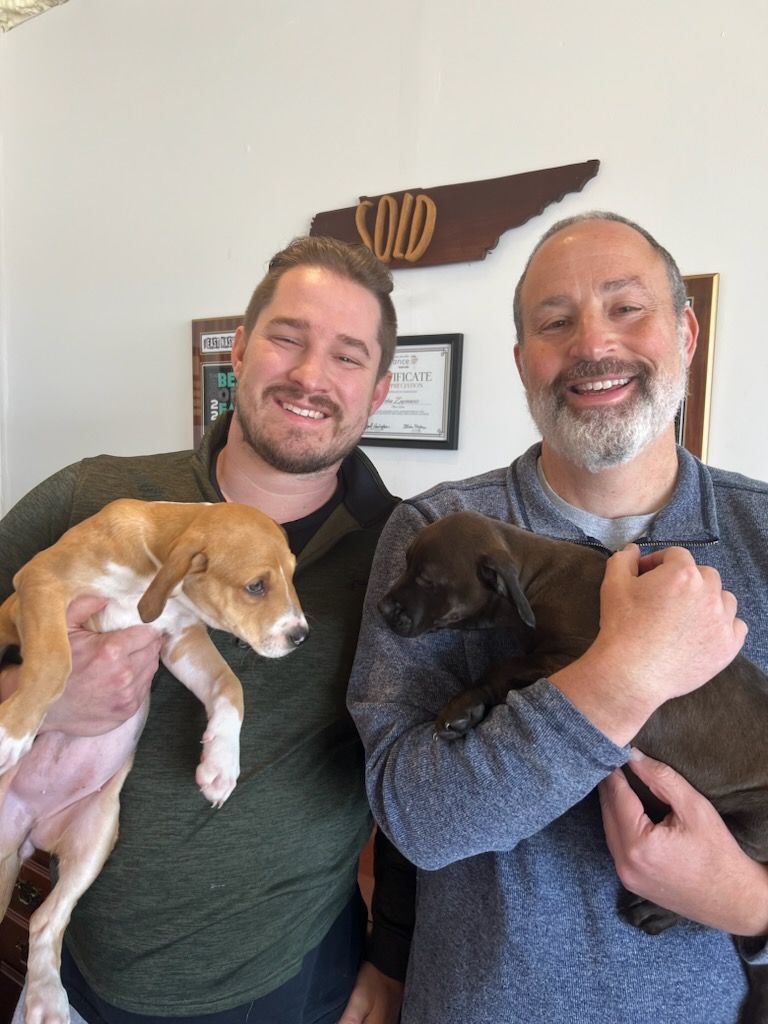 Muttz Realty team with adoptable dogs at office