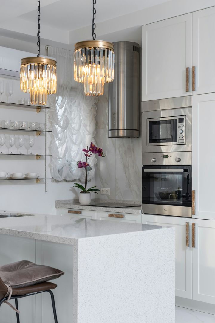 A kitchen with white cabinets and stainless steel appliances