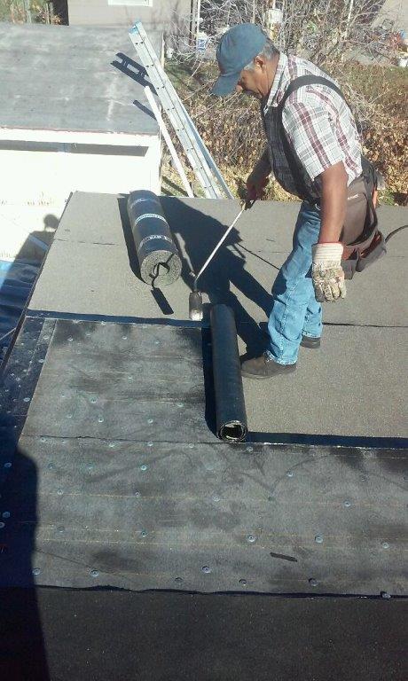 a man working on a roof with a roller .
