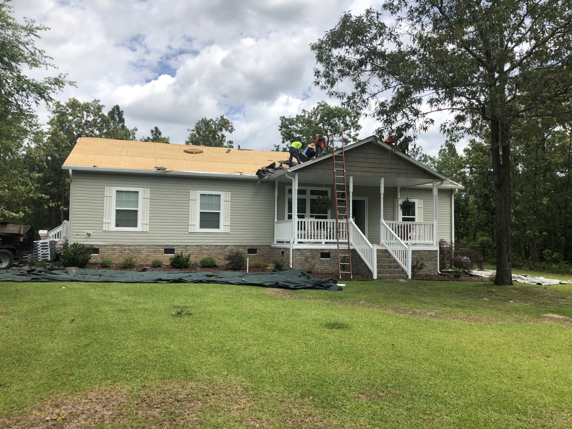 a house is being remodeled with a roof being installed .