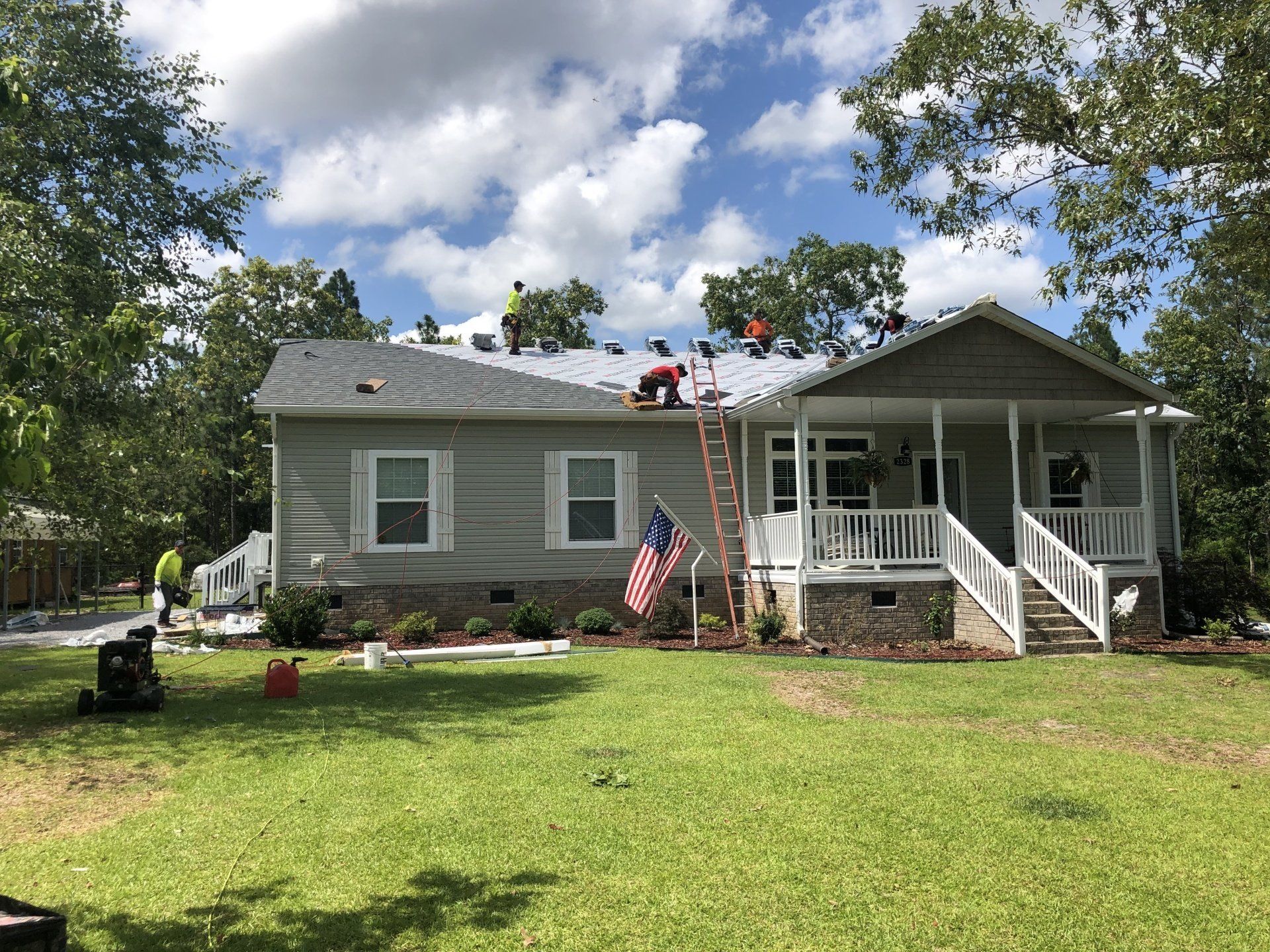 a group of people are working on the roof of a house .