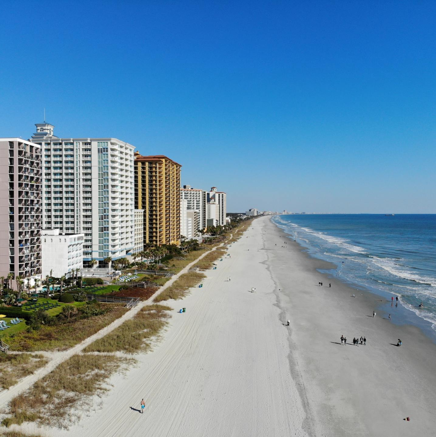 an aerial view of a beach with buildings in the background .